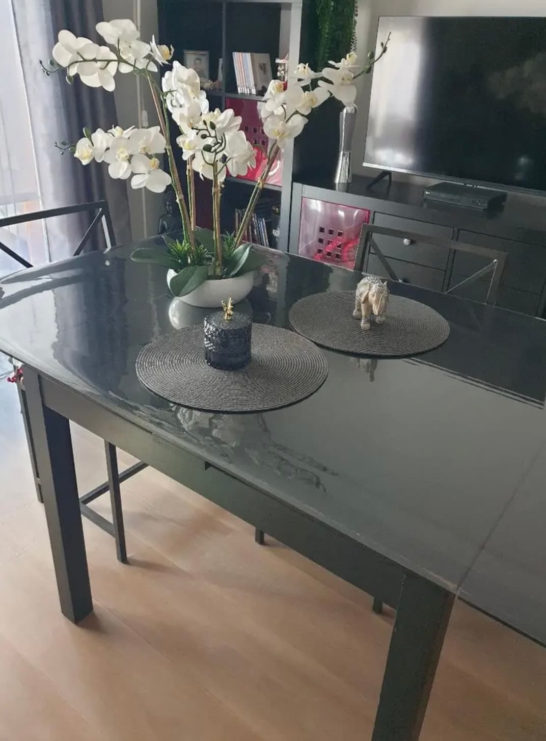 Grafitový stolík do obývačky s bielou orchideou a okrúhlymi prestieraniami, doska pod podložku