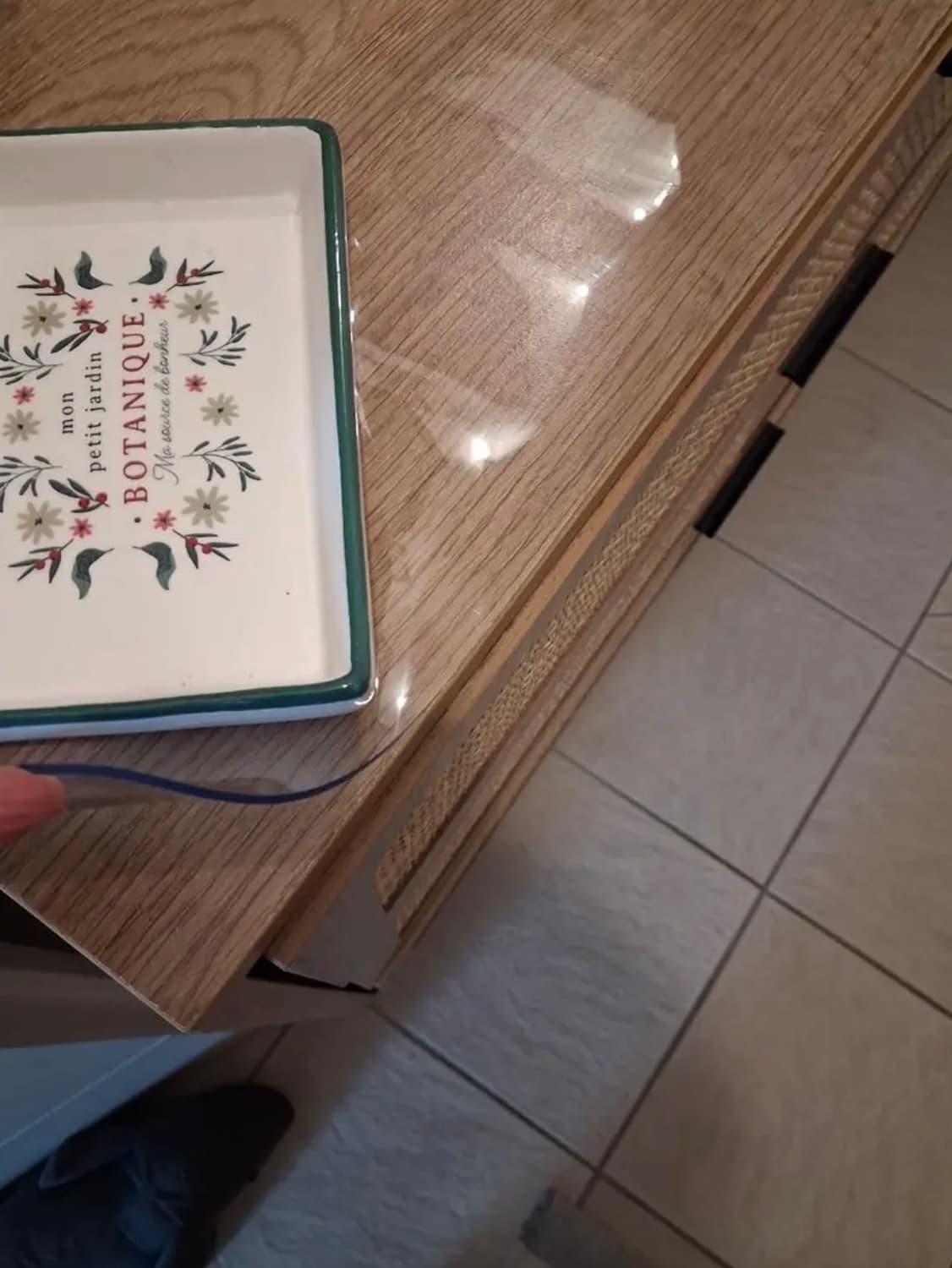 Roh dubovej komody s ozdobným podnosom; ruka drží okraj číreho prekrytia